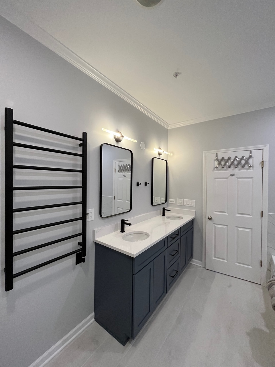 Updated bathroom with modern white cabinets and mirror lighting